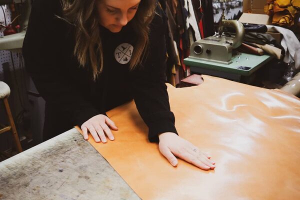 Image of Kristi owner of Tundra Lather working with a piece of leather - International Women's Day